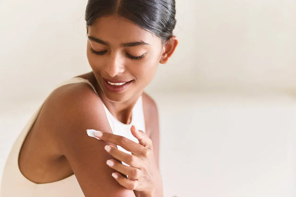 A woman with sensitive skin is patch testing a body care product on her arm